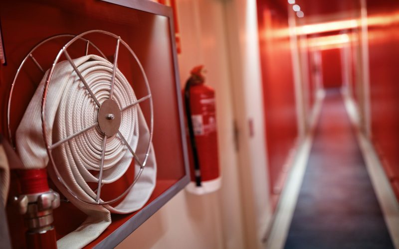 Fire extinguisher and hose reel in hotel corridor